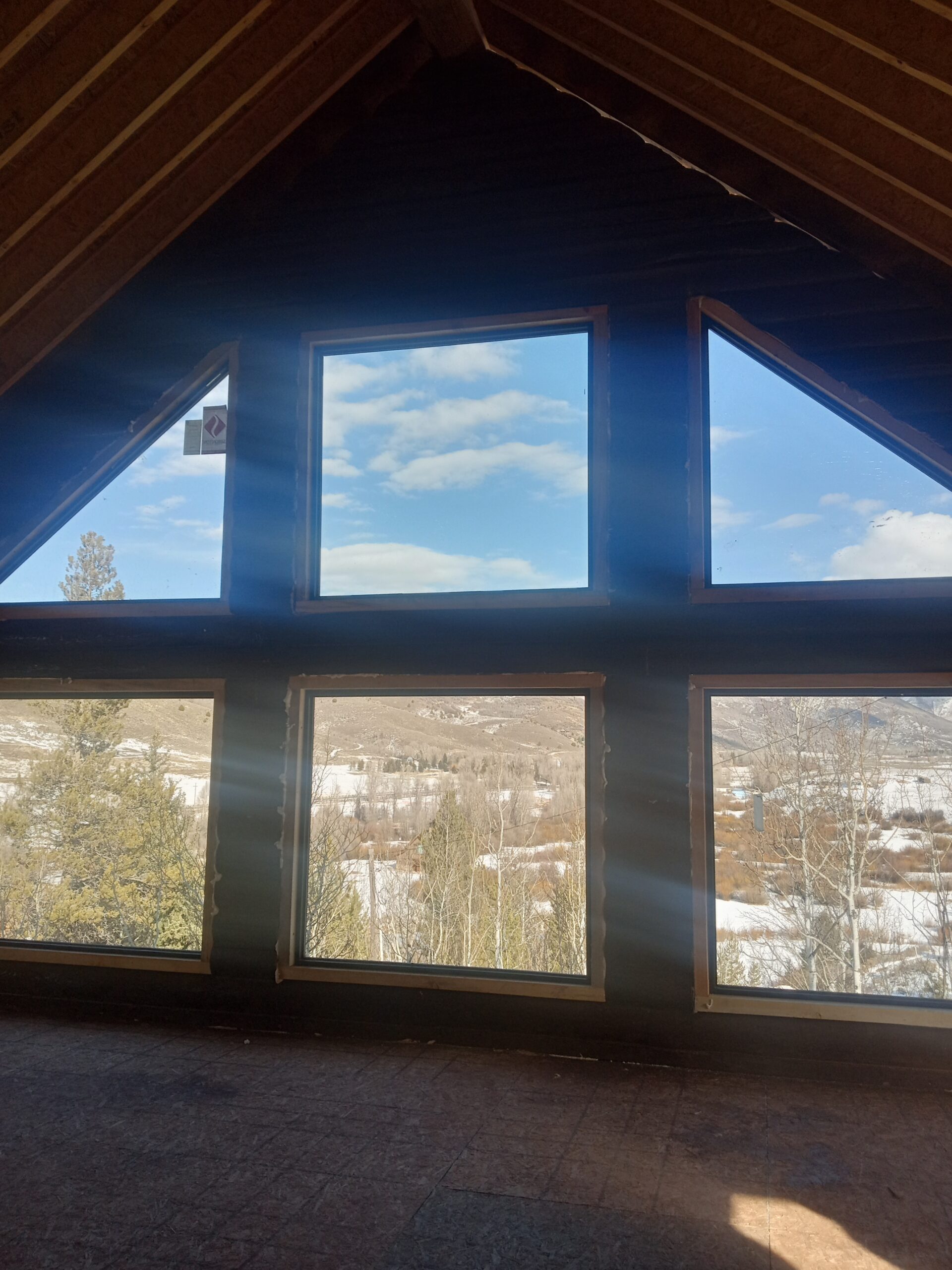 Mountain view through large windows of a custom Caribou log home