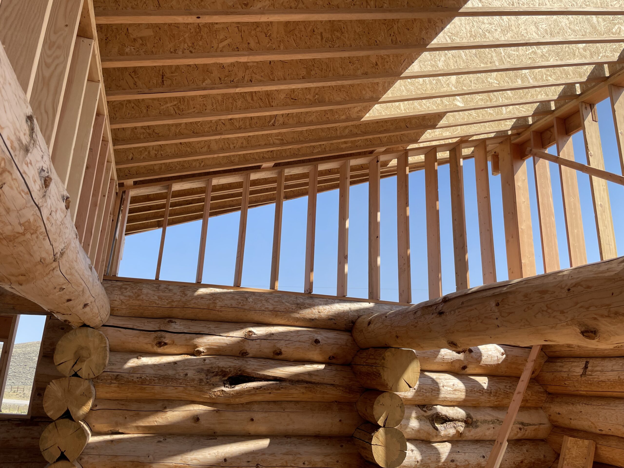 Upper framing and roof structure on the Burton handcrafted log home