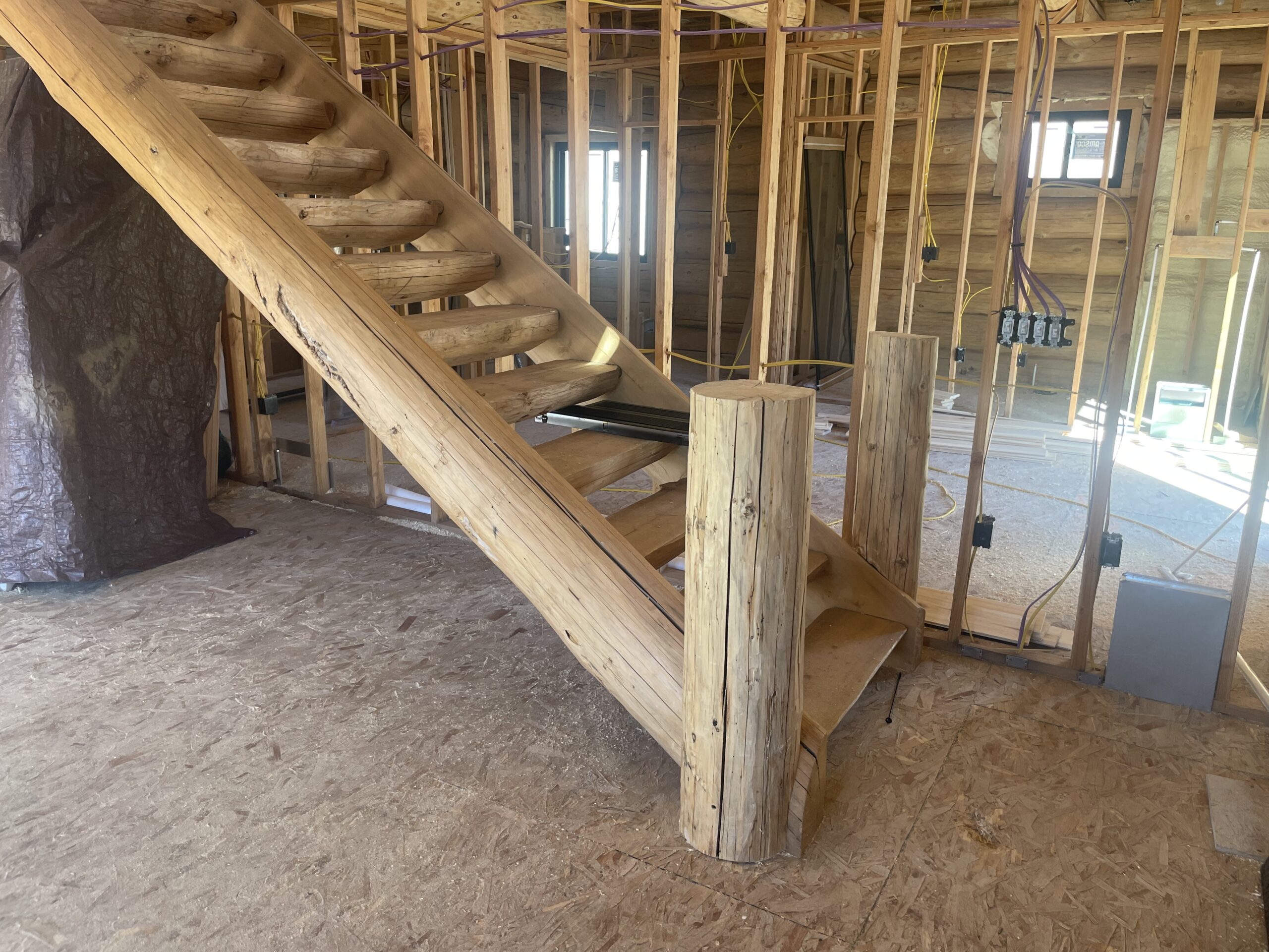 Handcrafted log staircase and railing inside the Collard's project